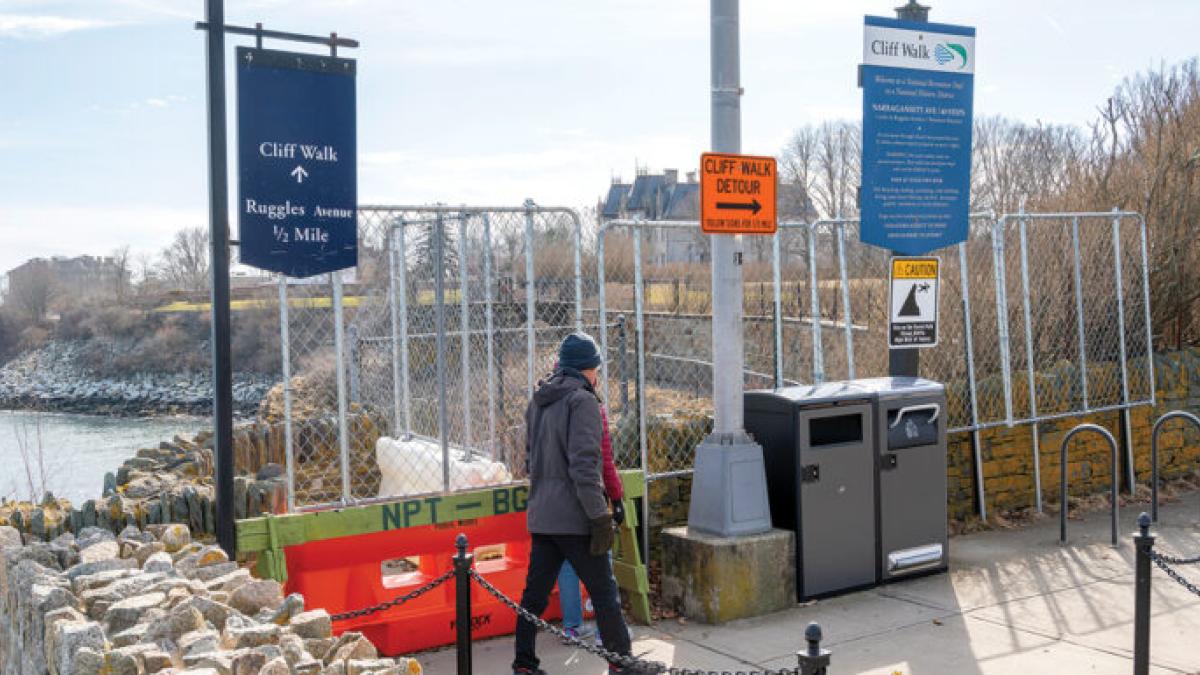 WALKERS HEADING south on the Newport Cliff Walk are stopped at Narragansett Avenue by fencing because part of the historic walk collapsed about two years ago. Visitors are required to detour through a nearby neighborhood to reconnect with the path farther south.